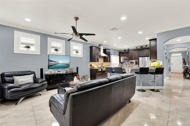 living room featuring crown molding and ceiling fan