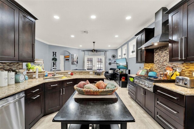 kitchen with wall chimney range hood, light tile patterned flooring, sink, stainless steel dishwasher, and ornamental molding