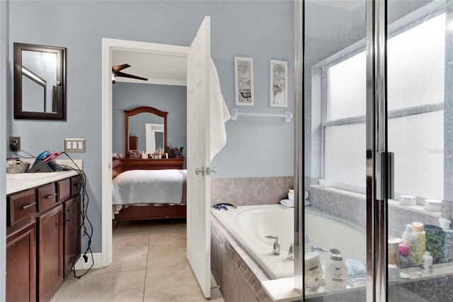 bathroom with ceiling fan, ornamental molding, vanity, tiled bath, and tile patterned flooring