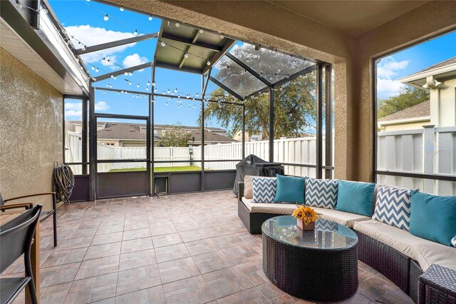 sunroom featuring rail lighting and lofted ceiling