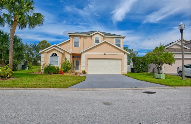 view of property featuring a front yard and a garage