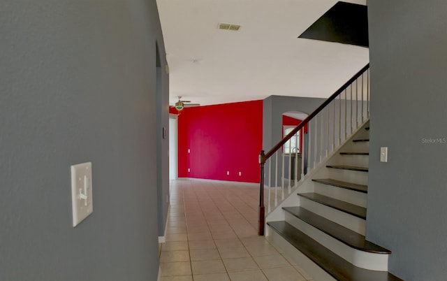 staircase with tile patterned floors and ceiling fan