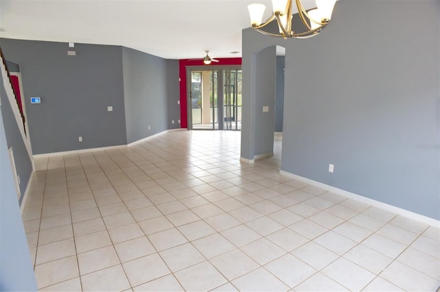 spare room with light tile patterned floors and ceiling fan with notable chandelier