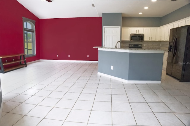 kitchen with an island with sink, white cabinetry, vaulted ceiling, black appliances, and sink