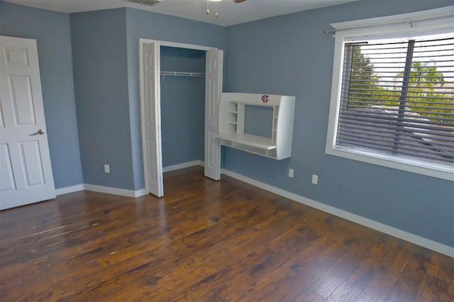 unfurnished bedroom with dark hardwood / wood-style floors and a closet