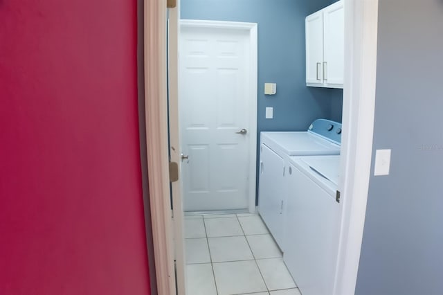 laundry area featuring cabinets, light tile patterned flooring, and washer and clothes dryer