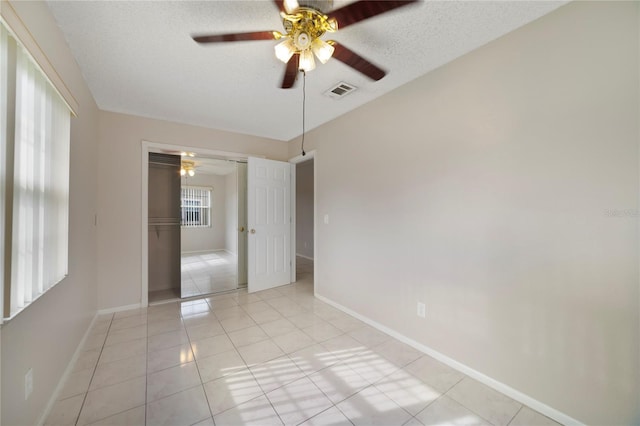 tiled spare room featuring ceiling fan and a textured ceiling