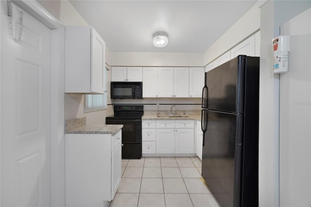 kitchen featuring sink, light stone countertops, black appliances, light tile patterned flooring, and white cabinetry