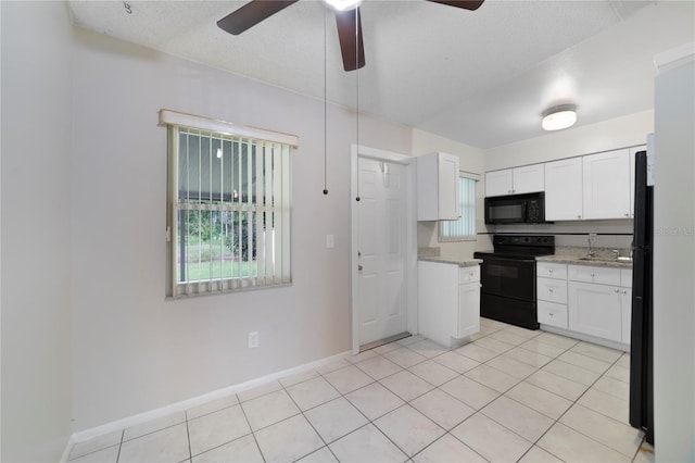 kitchen featuring white cabinets, light tile patterned floors, ceiling fan, black appliances, and light stone counters