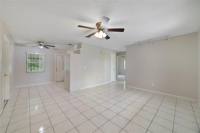 tiled spare room featuring a textured ceiling and ceiling fan