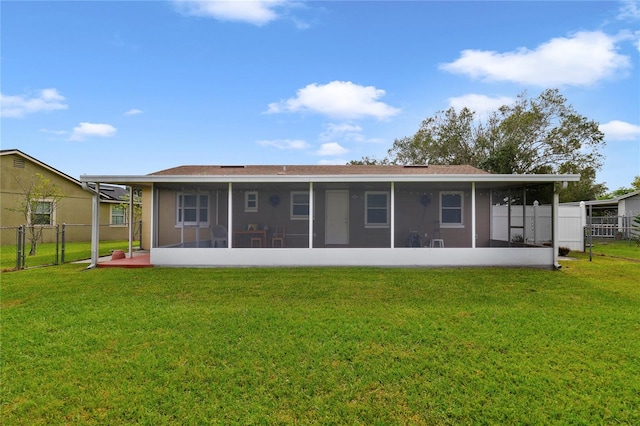 back of house featuring a lawn and a sunroom