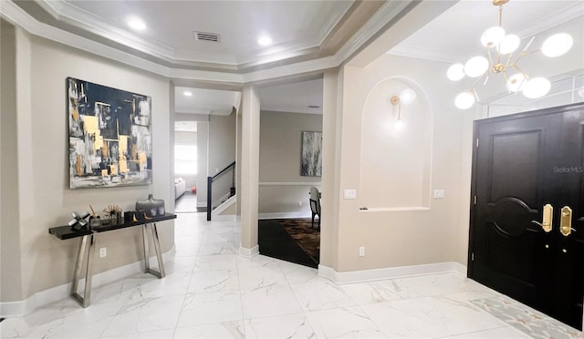 foyer with ornamental molding and a notable chandelier