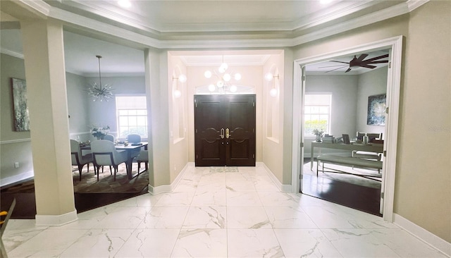 entryway featuring ceiling fan with notable chandelier and crown molding