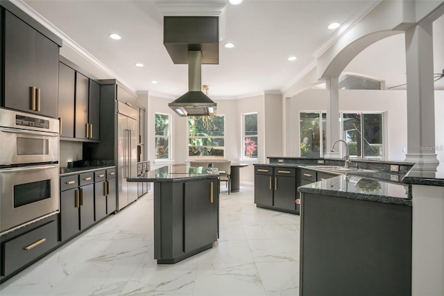 kitchen featuring sink, a center island, double oven, dark stone counters, and ornamental molding