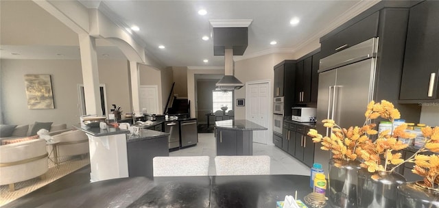 kitchen with a breakfast bar, dark stone counters, crown molding, a kitchen island, and stainless steel appliances