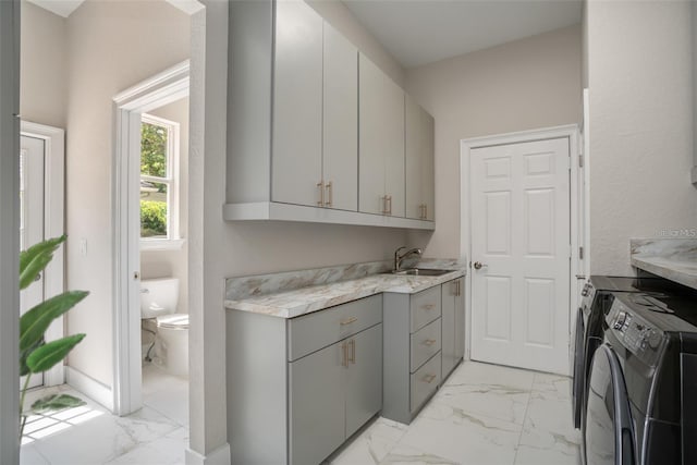 laundry area with cabinets, sink, and washing machine and clothes dryer