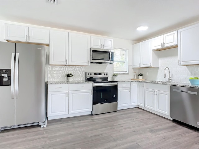 kitchen featuring sink, white cabinets, appliances with stainless steel finishes, and light wood-type flooring