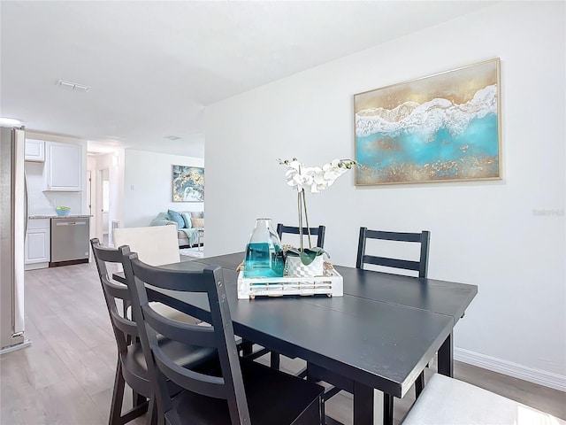 dining space with light hardwood / wood-style floors