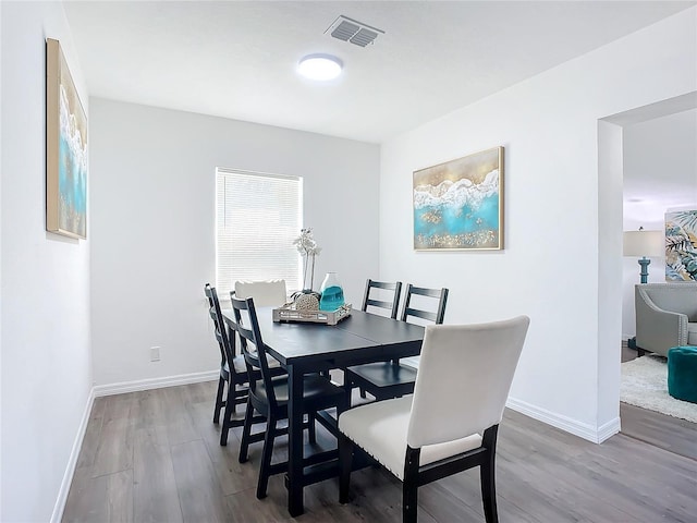 dining space with hardwood / wood-style flooring