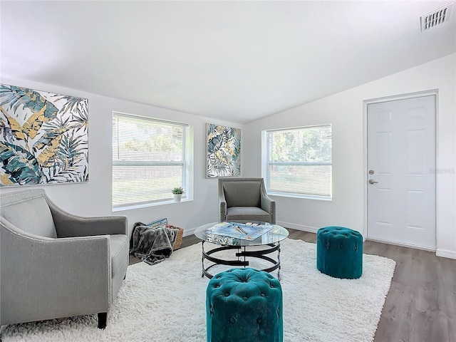 living area with vaulted ceiling and hardwood / wood-style floors