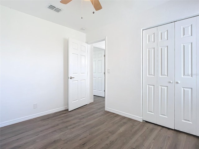 unfurnished bedroom with ceiling fan, a closet, and dark hardwood / wood-style flooring