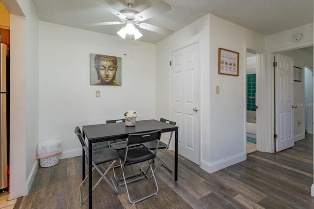 dining space featuring a textured ceiling, ceiling fan, and dark hardwood / wood-style flooring