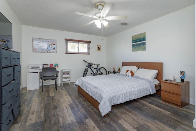 bedroom featuring dark hardwood / wood-style floors, a textured ceiling, and ceiling fan