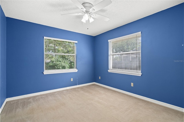 carpeted spare room featuring ceiling fan and a textured ceiling