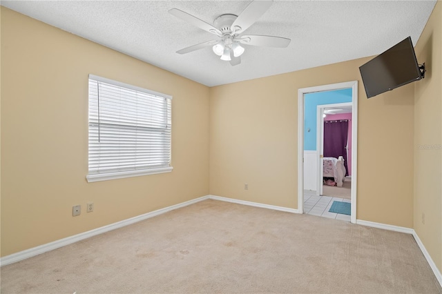 carpeted empty room featuring a textured ceiling and ceiling fan