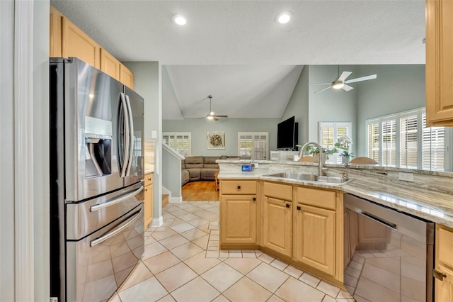 kitchen with light brown cabinets, light tile patterned floors, appliances with stainless steel finishes, a textured ceiling, and sink