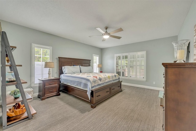bedroom with a ceiling fan, baseboards, and light colored carpet