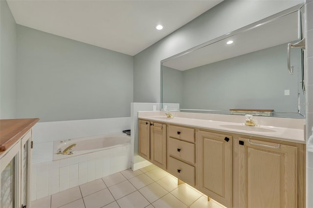 bathroom featuring vanity, a relaxing tiled tub, and tile patterned floors