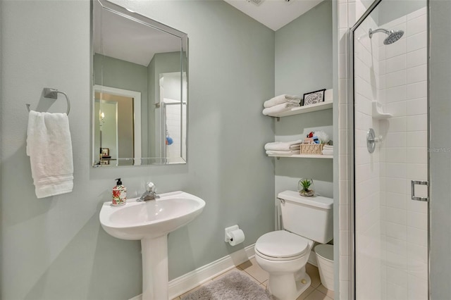 bathroom featuring a shower with door, toilet, and tile patterned flooring