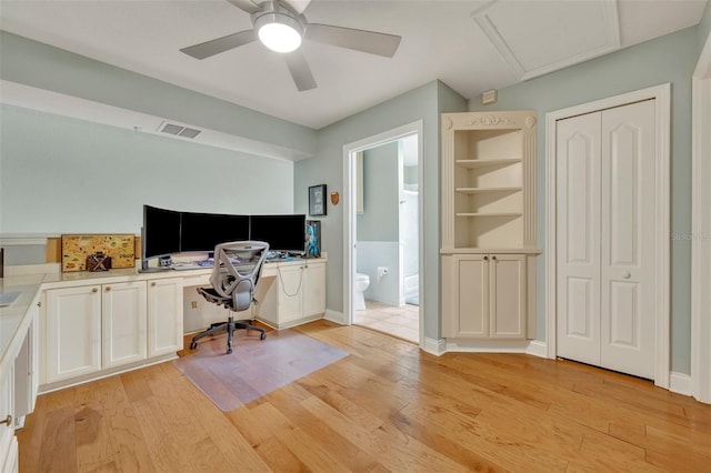 home office with visible vents, baseboards, attic access, ceiling fan, and light wood finished floors