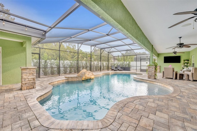 view of swimming pool with ceiling fan, an outdoor hangout area, glass enclosure, and a patio area