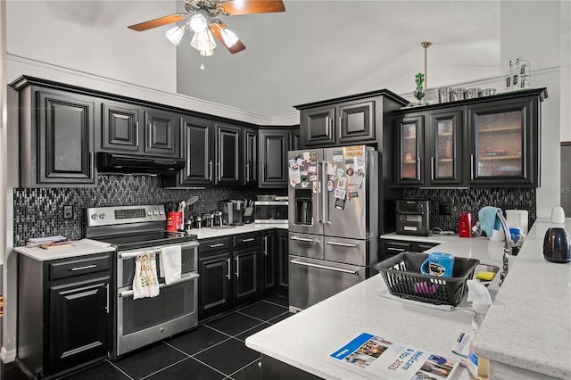 kitchen with dark tile patterned floors, lofted ceiling, decorative backsplash, stainless steel appliances, and ceiling fan