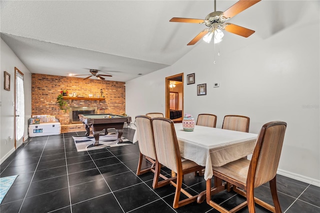 dining room featuring brick wall, billiards, a fireplace, and dark tile patterned floors