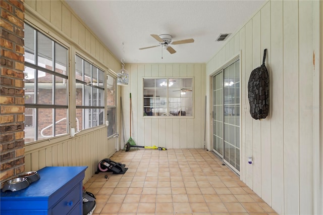 unfurnished sunroom featuring ceiling fan