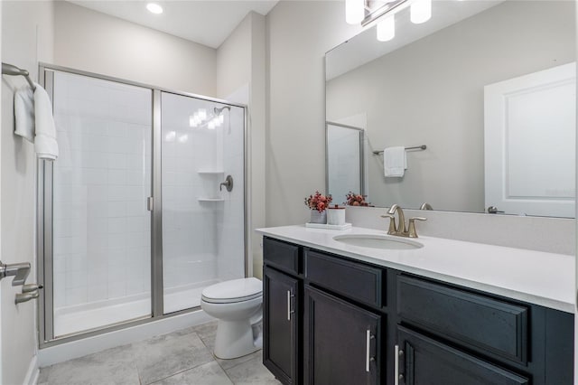 bathroom featuring vanity, a shower with shower door, and toilet