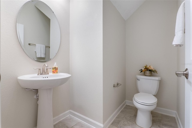 bathroom featuring vaulted ceiling, toilet, and tile patterned flooring