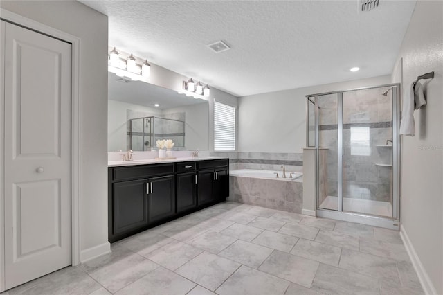 bathroom with tile patterned flooring, plus walk in shower, vanity, and a textured ceiling