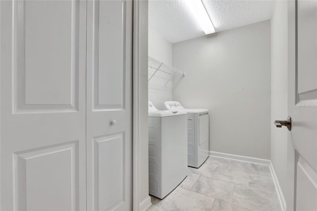 washroom featuring separate washer and dryer and a textured ceiling