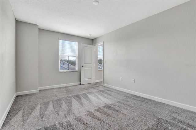 unfurnished room featuring carpet flooring and a textured ceiling