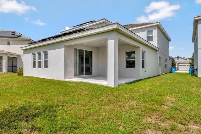 back of property with a yard and a patio area