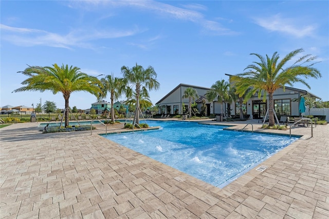 view of swimming pool with pool water feature and a patio area