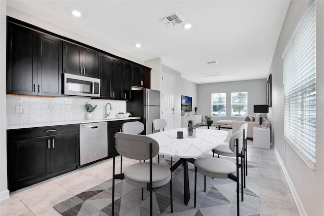 kitchen with visible vents, open floor plan, light countertops, appliances with stainless steel finishes, and dark cabinetry