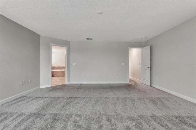 empty room with light colored carpet, visible vents, and baseboards