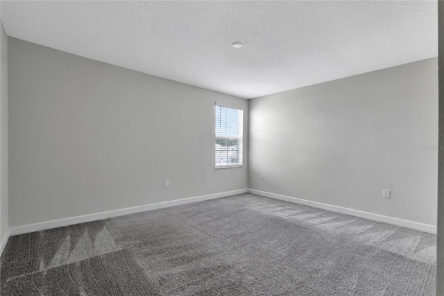 unfurnished room featuring carpet floors, baseboards, and a textured ceiling