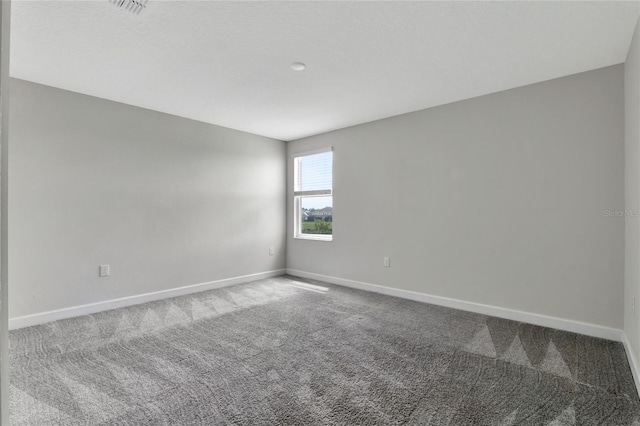 carpeted empty room featuring visible vents and baseboards