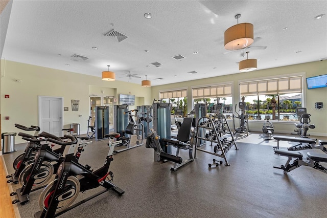 gym featuring baseboards, visible vents, and a textured ceiling